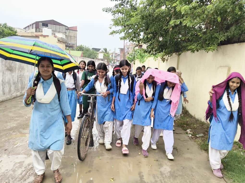 रॉबर्ट्सगंज में हल्की बारिश में स्कूल से घर जाती छात्राएं। संवाद