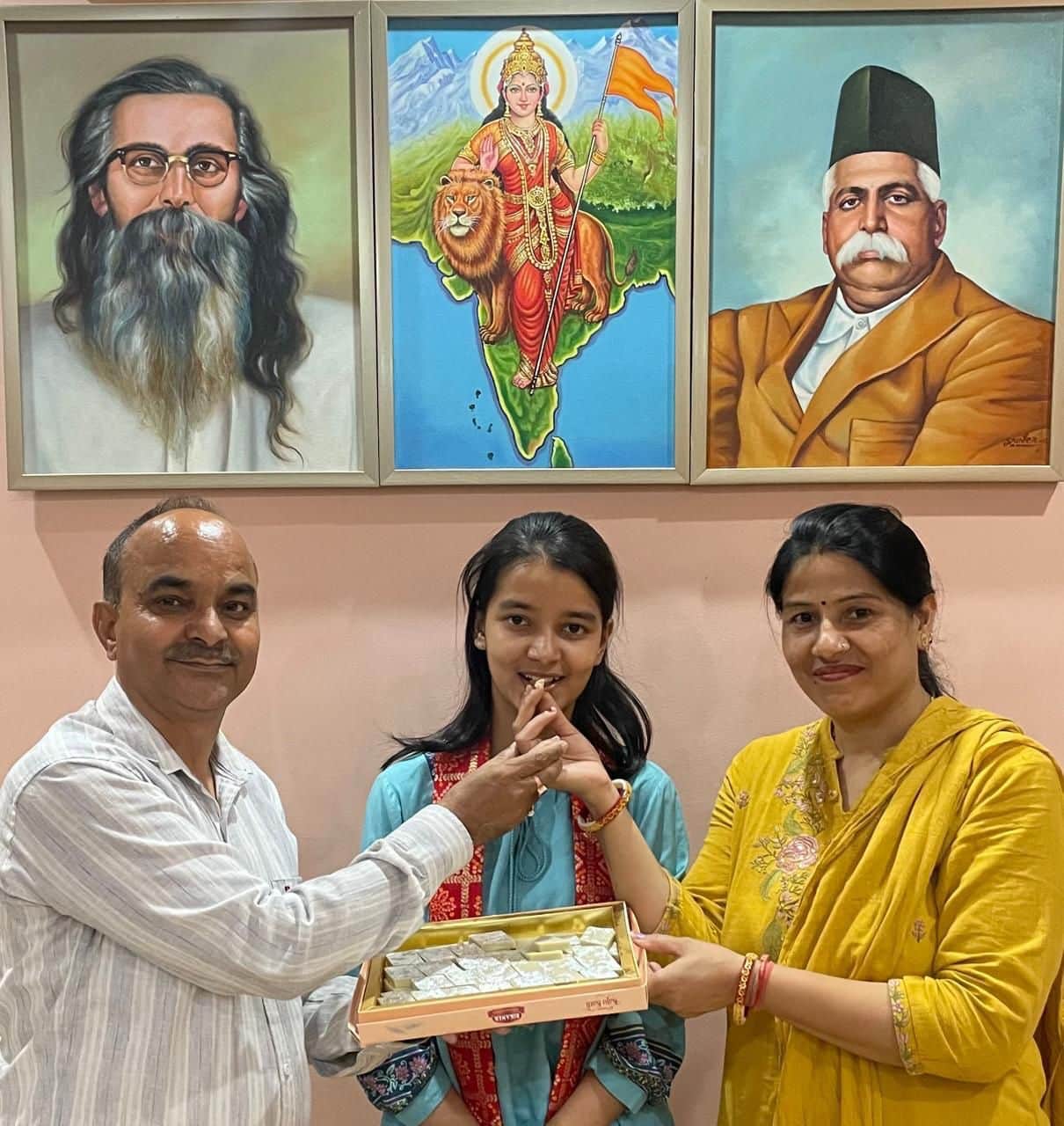 ऋषिकेश शहर की इंटरमीडिएट टॉपर अन्वेषा भट्ट को मिठाई खिलाकर बधाई देते माता-पिता। स्रोत जागरूक 