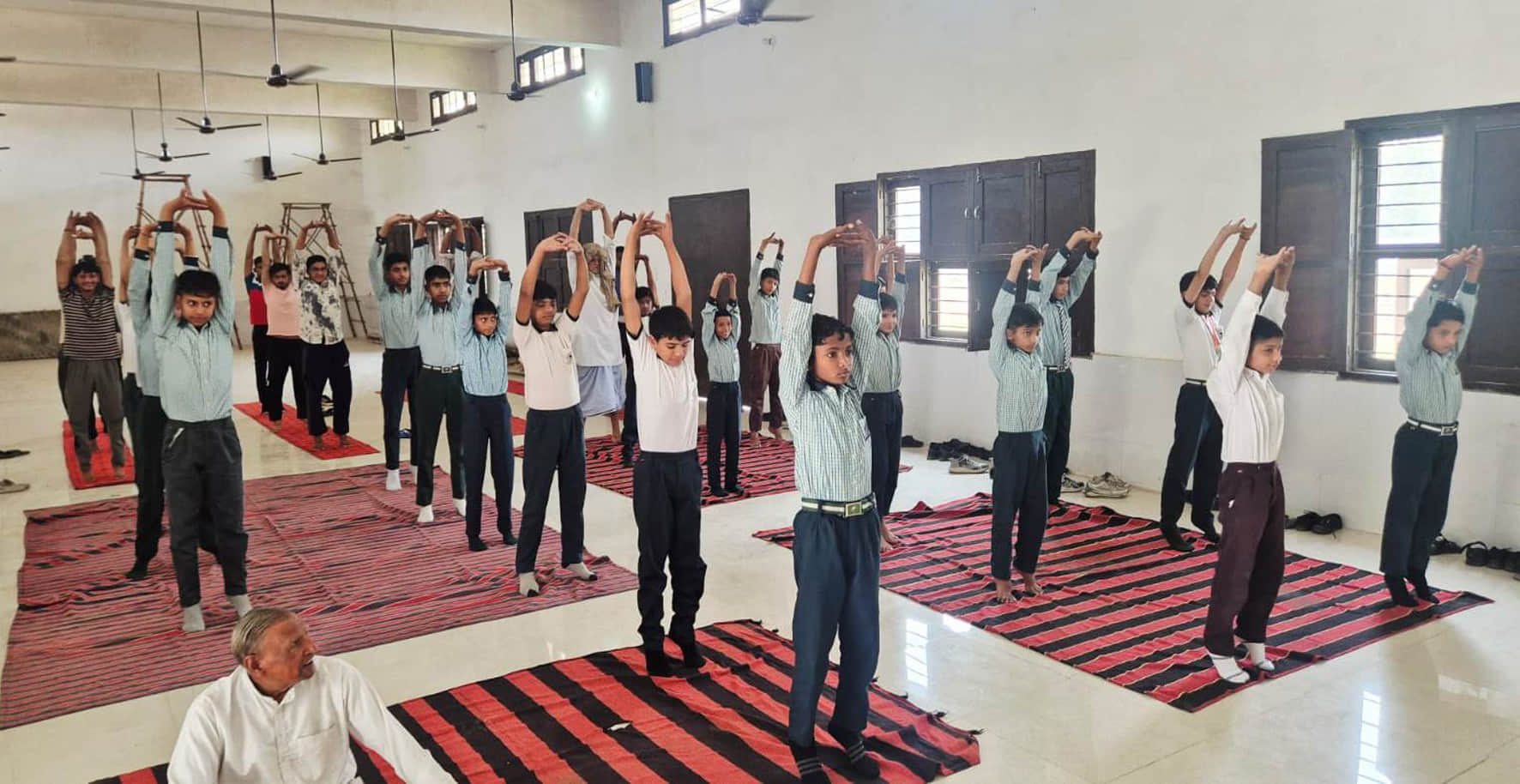 डीग में योगाभ्यास करवाते योग प्रशिक्षक।