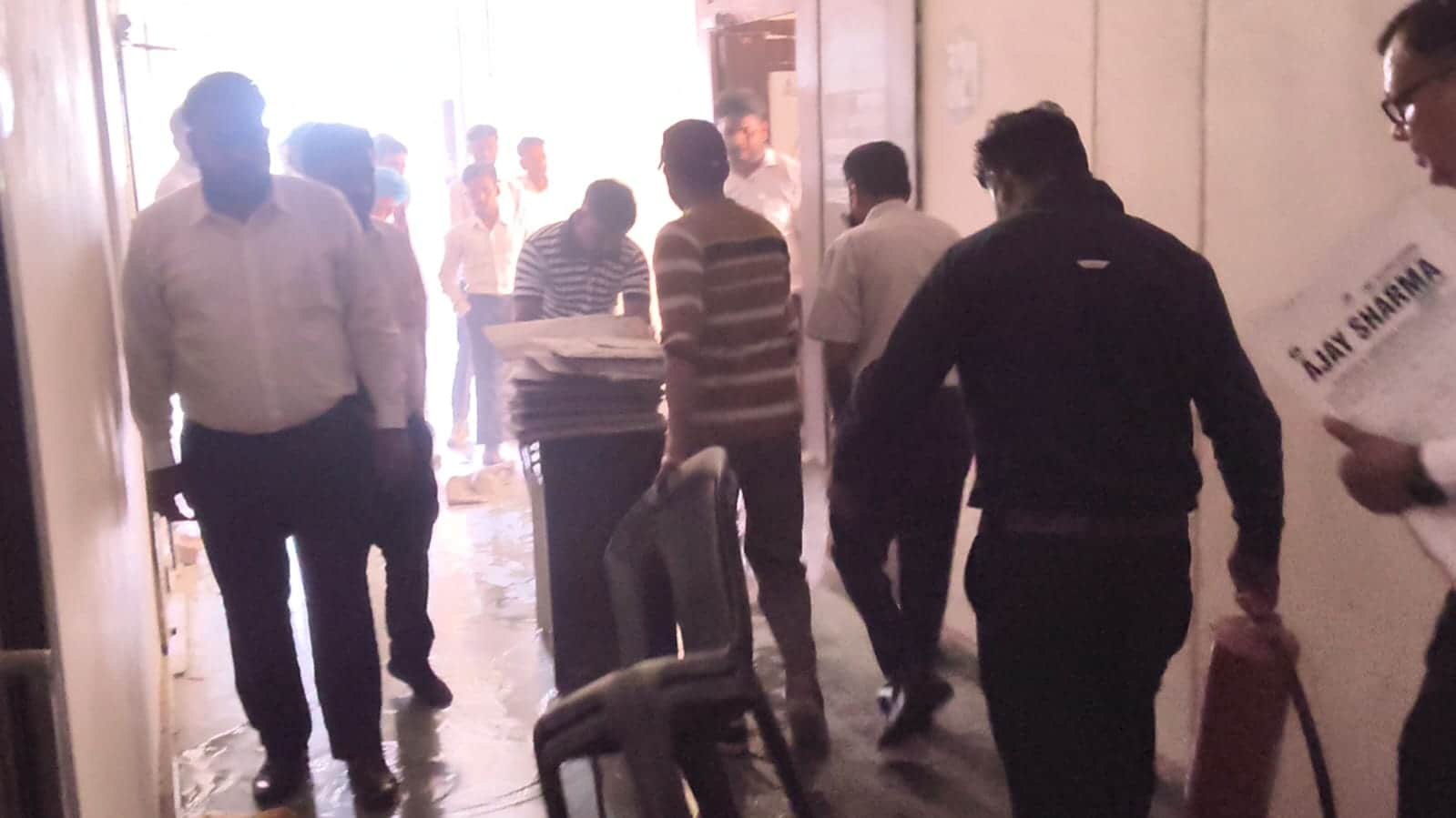 एसी में ब्लास्ट होने के बाद सामान को निकालते लोग। संवाद