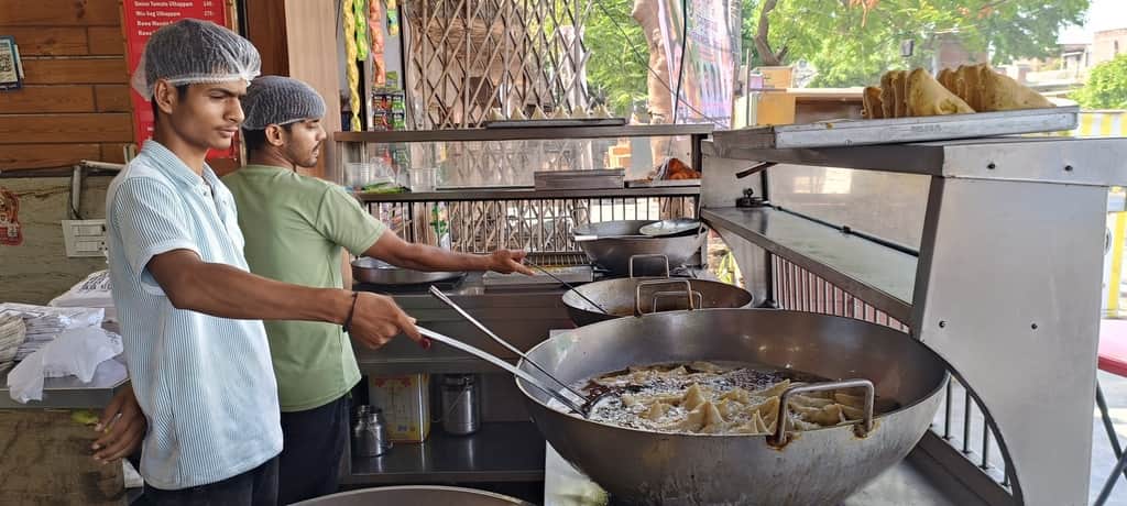 फोटो 1 स्टेशन रोड पर मौजूद प्रतिष्ठान पर व्यावसायिक गैस सिलिंडर की मदद से समोसे बनाता कर्मचारी।