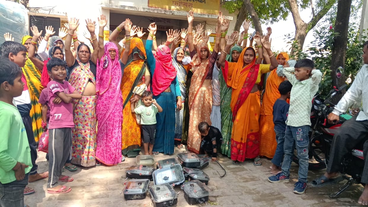 Women protest against smart meters, uproot meters and throw them at the substation.