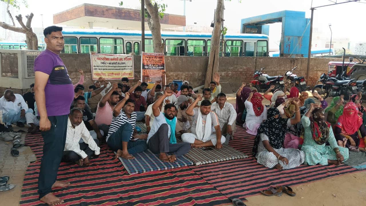 नप कार्यालय के सामने हड़ताल पर बैठे कर्मचारी। 