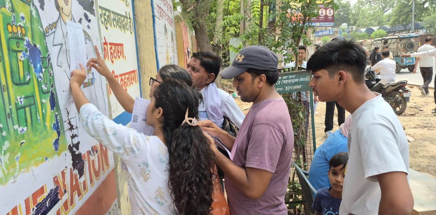 रीक्षा केंद्र के बाहर  लगी सूची में अपना रोल नंबर देखते परीक्षार्थी। 