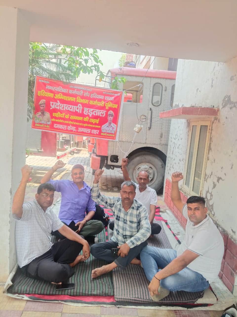 शहर के फायर स्टेशन पर दमकल कर्मी नारेबाजी करते हुए। प्रवक्ता