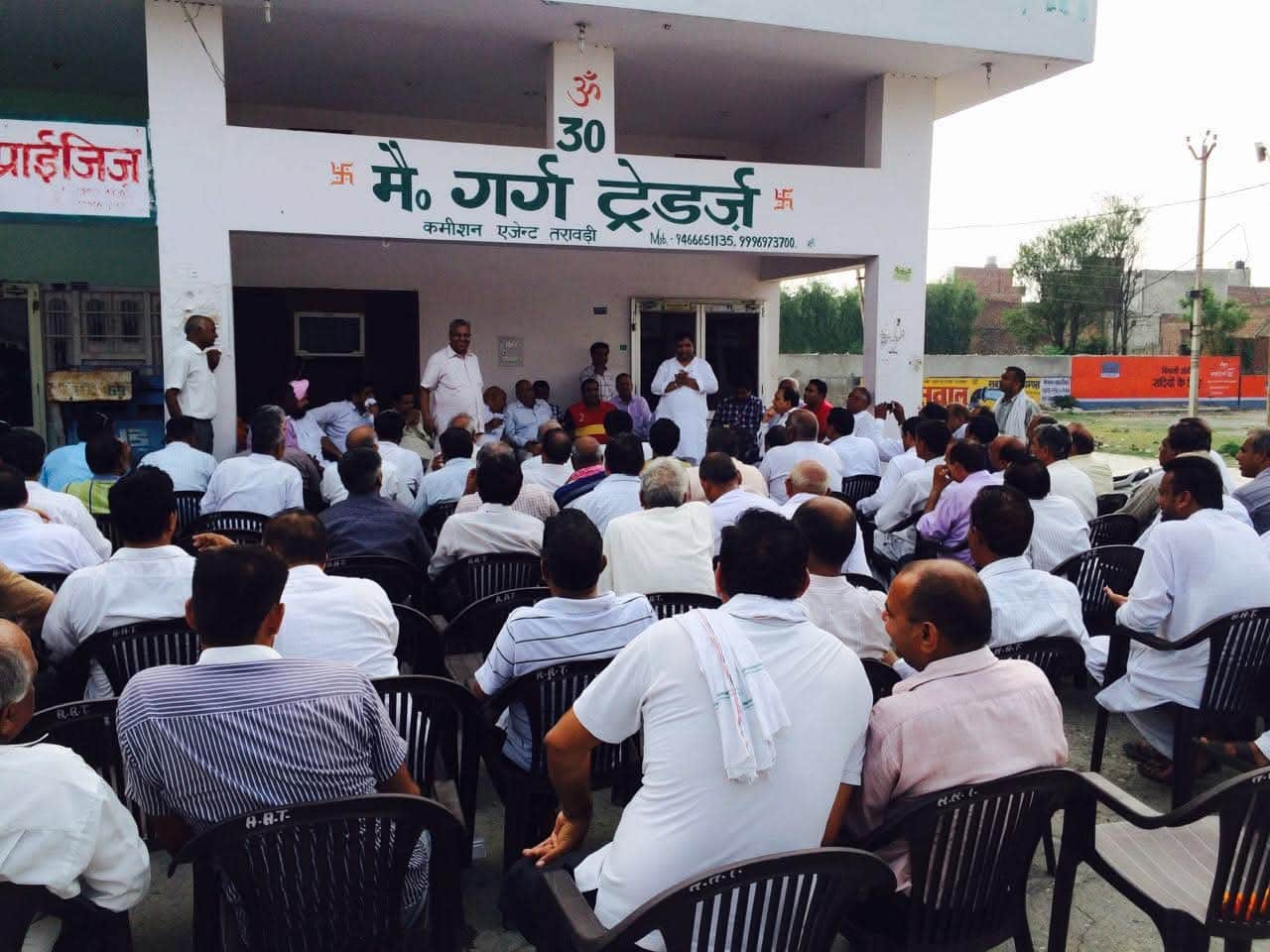 तरावड़ी मंडी प्रधान की दुकान के बाहर बैठक में शामिल आढ़ती। संवाद