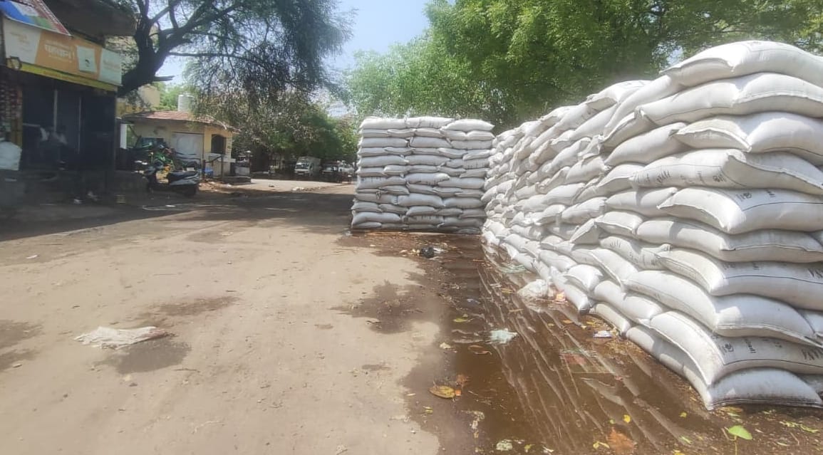 Rain soaked wheat in the market, tarpaulin covering the heaps was also done.