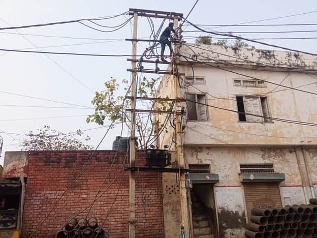 बिजली लाइनों की मरम्मत करते हुए कर्मचारी। 