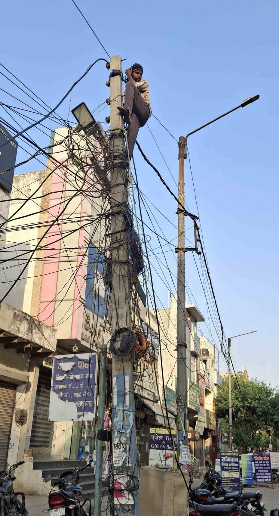 -फोटो-53 : बहादुरगढ़ में दिल्ली-रोहतक रोड पर बिना ग्लव्स, जूते और हेलमेट के खंभे पर चढ़कर काम करत