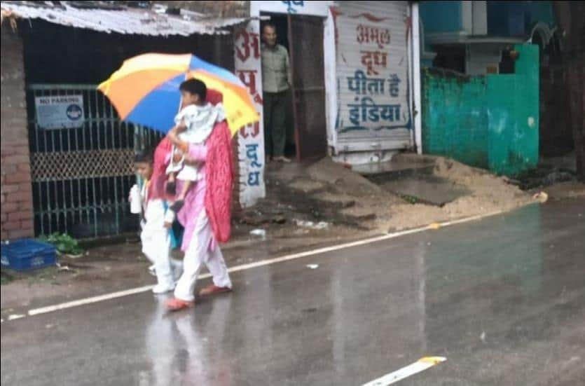 फोटो-15-सोमवार को बारिश के दौरान छाता लगाकर जाती महिला। स्रोत: आर्काइव।