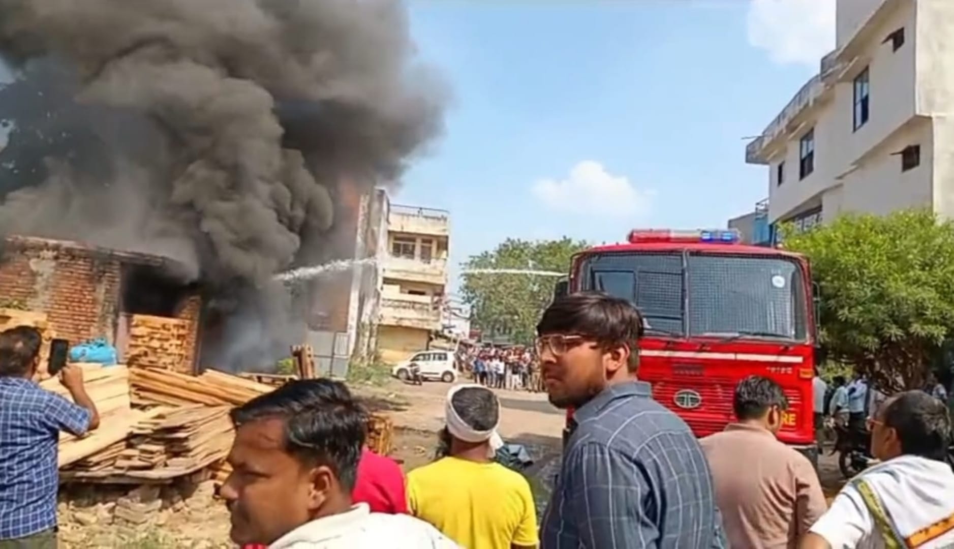 महमूदपुर मनौरी स्थित गैरेज में खड़ी कार में आग लगने के बाद उठता धुआं। संवाद