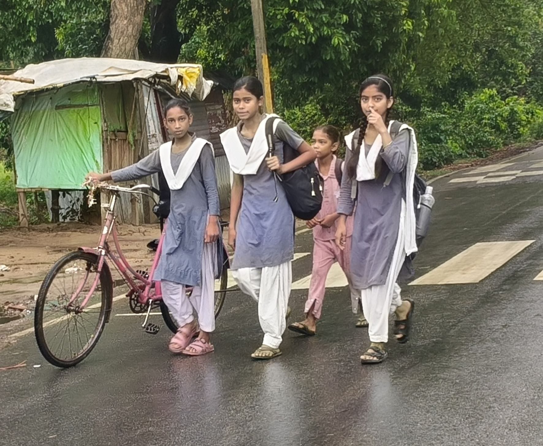 कोटवाधाम क्षेत्र में  बारिश के दौरान  स्कूल जाते छात्राएं ।