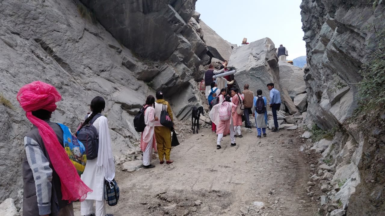 पस्सियां गिरने से ठप हुए मार्ग से पैदल गुजरते लोगसंवाद