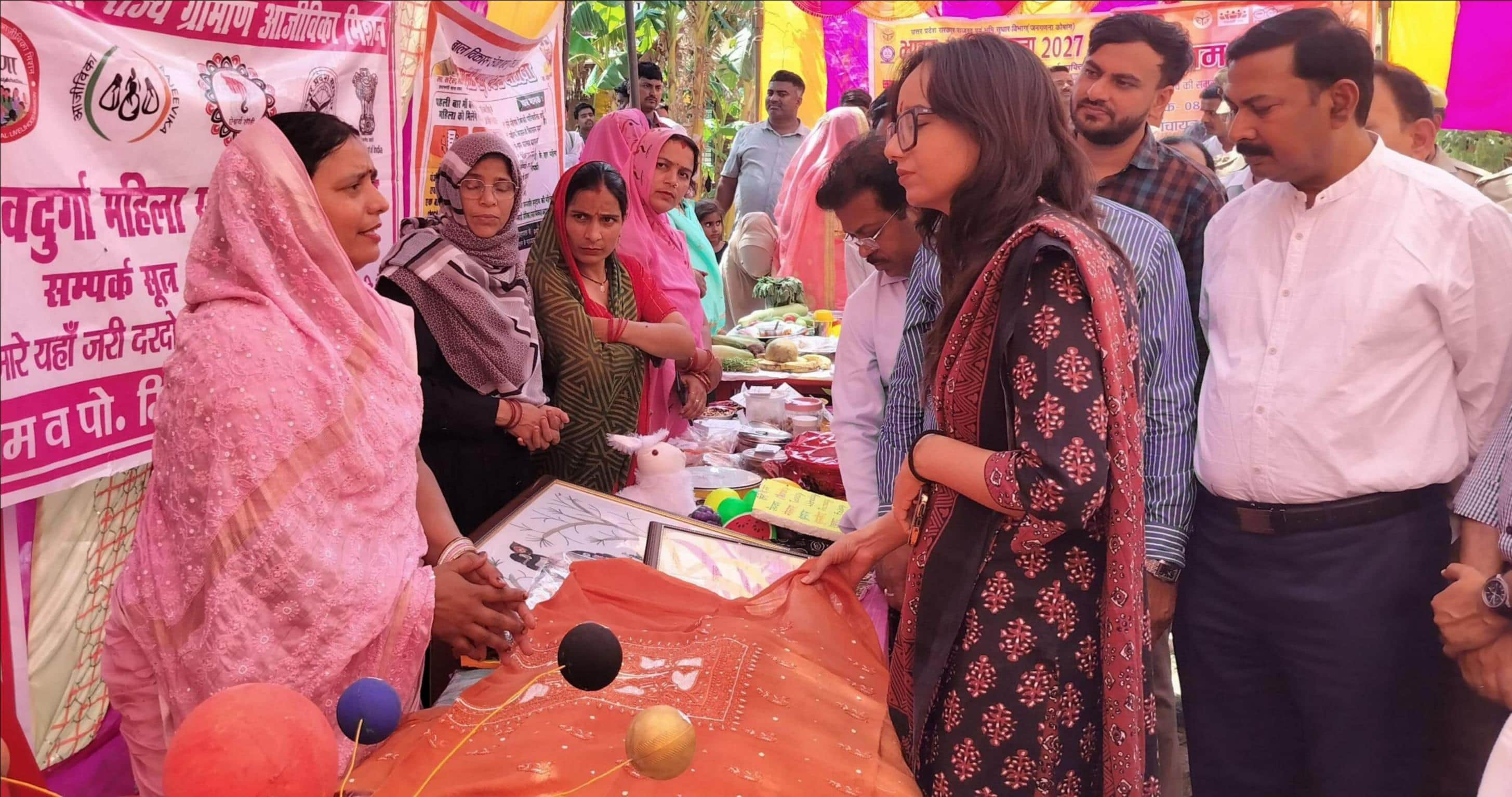 फोटो-28- ग्राम चौपाल में स्टाल पर समूह संचालिका सरोजनी से जानकारी लेतीं सीडीओ कृति राज। संवाद