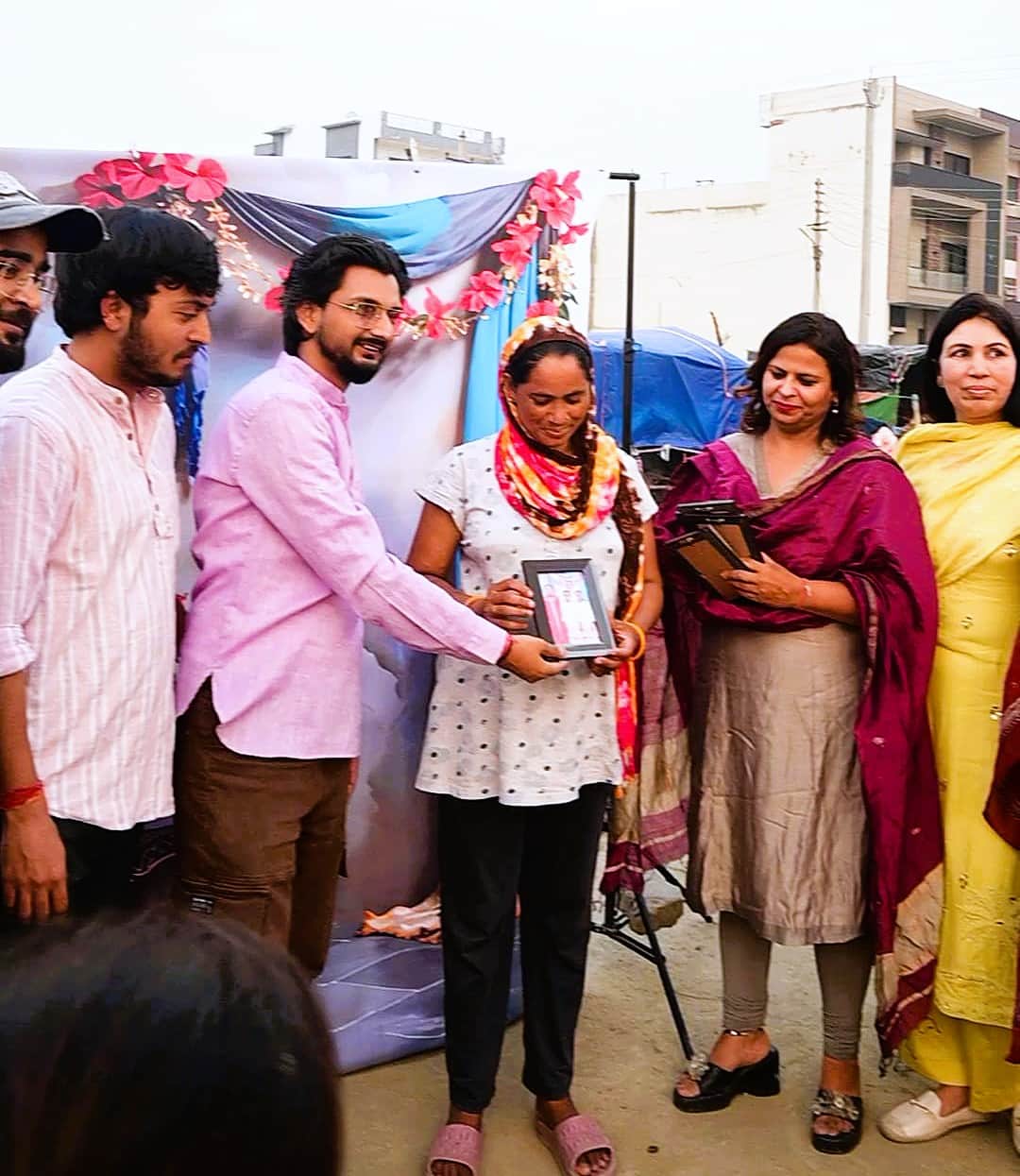 महिला को सम्मानित करते बिहाइंड द शटर के सदस्य। स्वयं