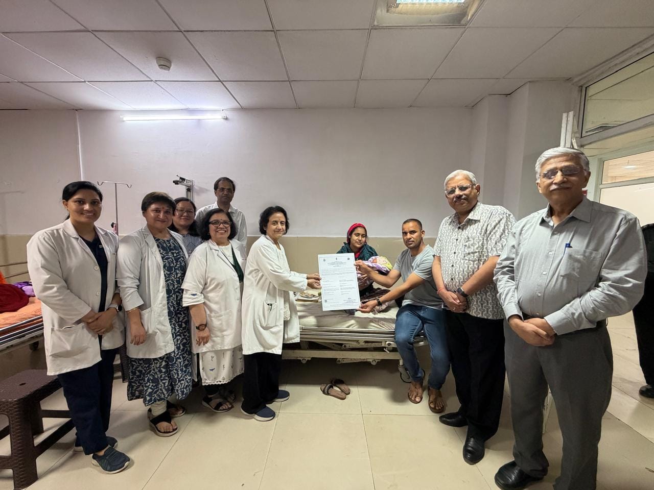 नवजात के परिजनों को जन्म प्रमाण पत्र जारी करती एम्स निदेशक प्रो. मीनू सिंह व गायनी विभगाध्यक्ष 