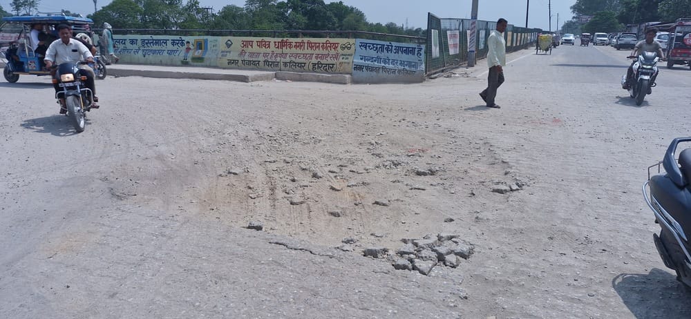 Deep pothole formed due to road break at intersection