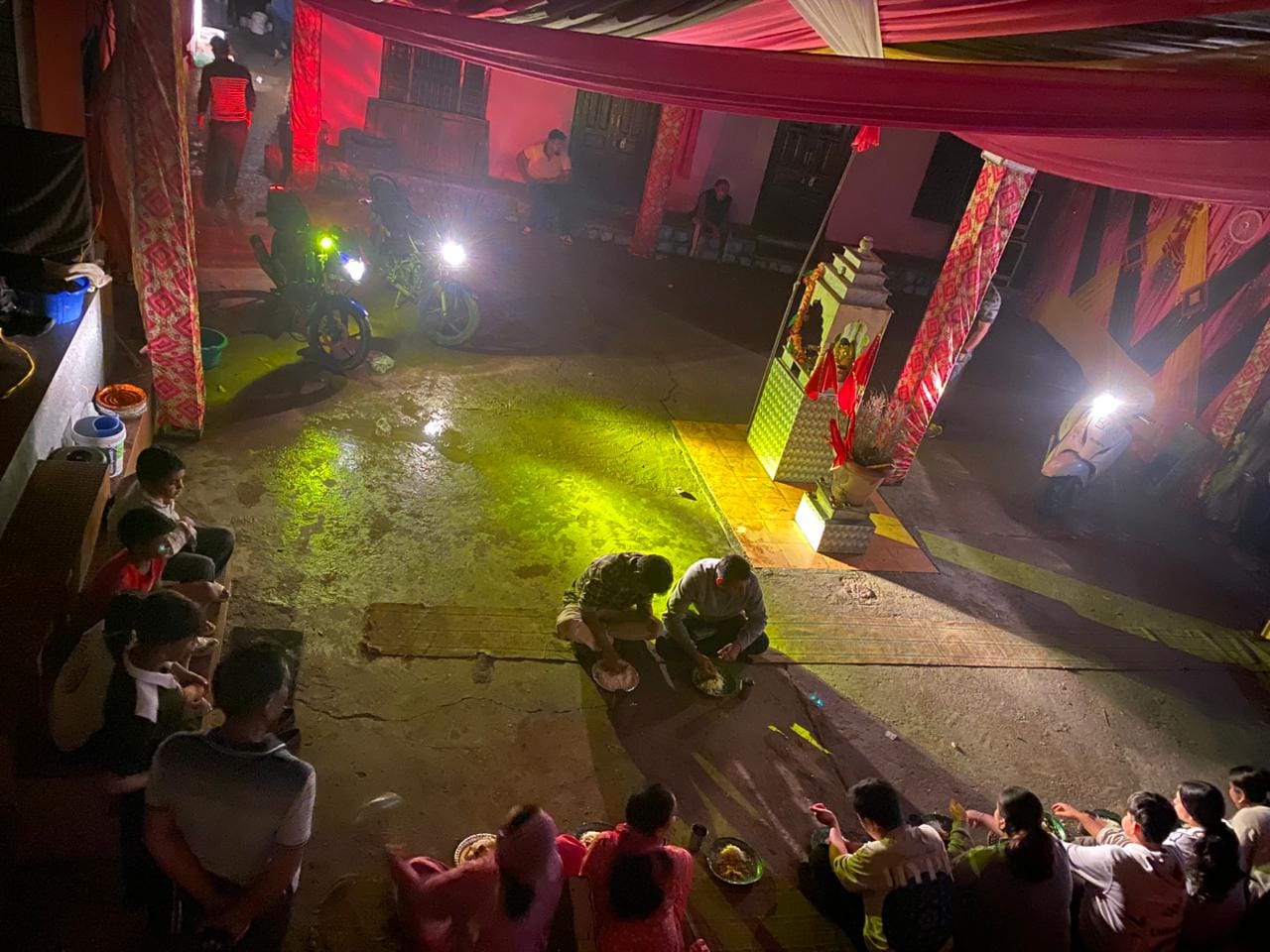 कंडबाड़ी में बाइक की हेडलाइट की रोशनी में खाना खाते मेहमान। -स्रोत : जागरूक पाठक