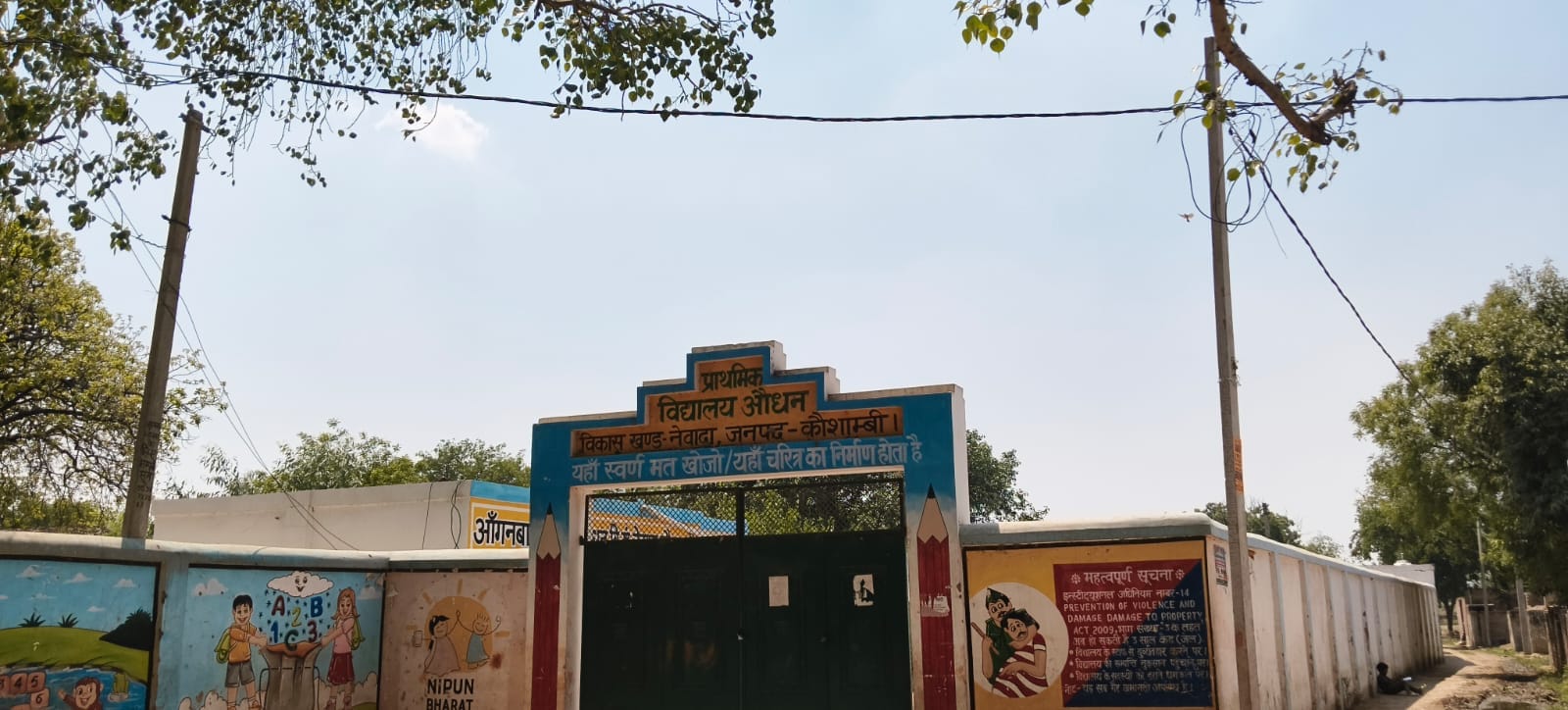 नेवादा के औधन गांव स्थित परिषदीय विद्यालय की दीवार से सटा हुआ बिजली का पोल और तार। संवाद