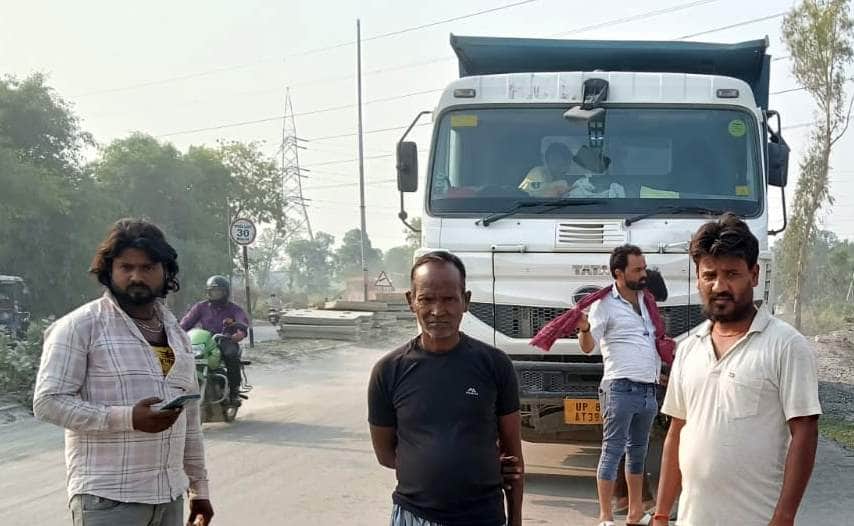 पलिया-लखनऊ मार्ग पर ग्राम गुंवारी के पास डंपर को रोके खड़े ग्रामीण। स्रोत: जागरूक पाठक
