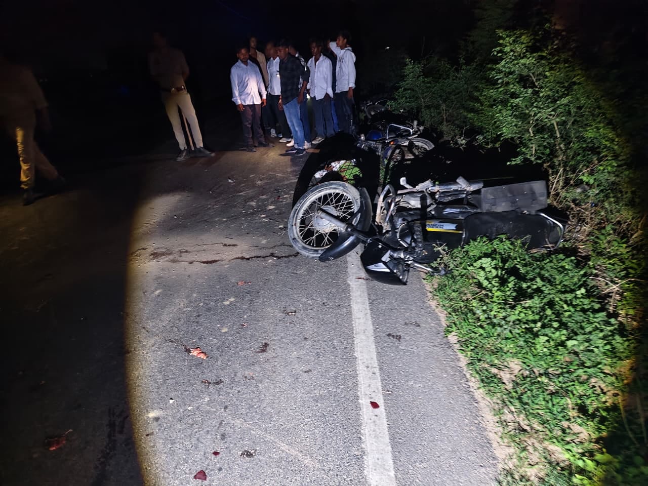 घटना के बाद सड़क के किनारे पड़ी क्षतिग्रस्त बाइक व लोगों की भीड़। स्रोत: पुलिस