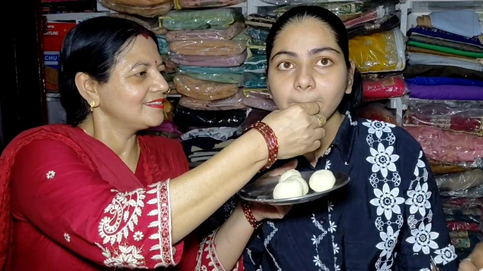 सीबीएसई में टाॅपर माही कुमारी को मिठाई खिलाते माता-पिता