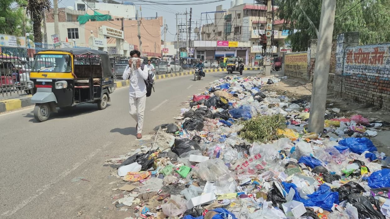 The strike has led to heaps of garbage in the city, with people covering their faces amid the stench.