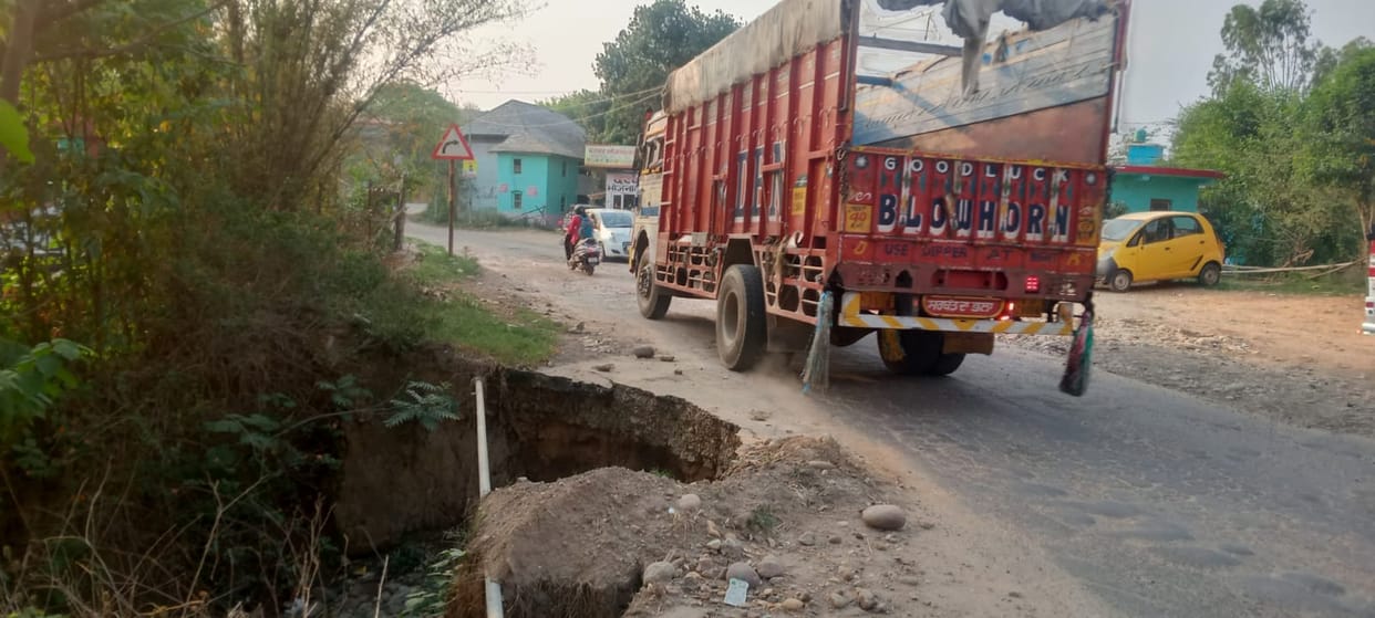 Potholes on the roadside in Talai village increase the risk of accidents.