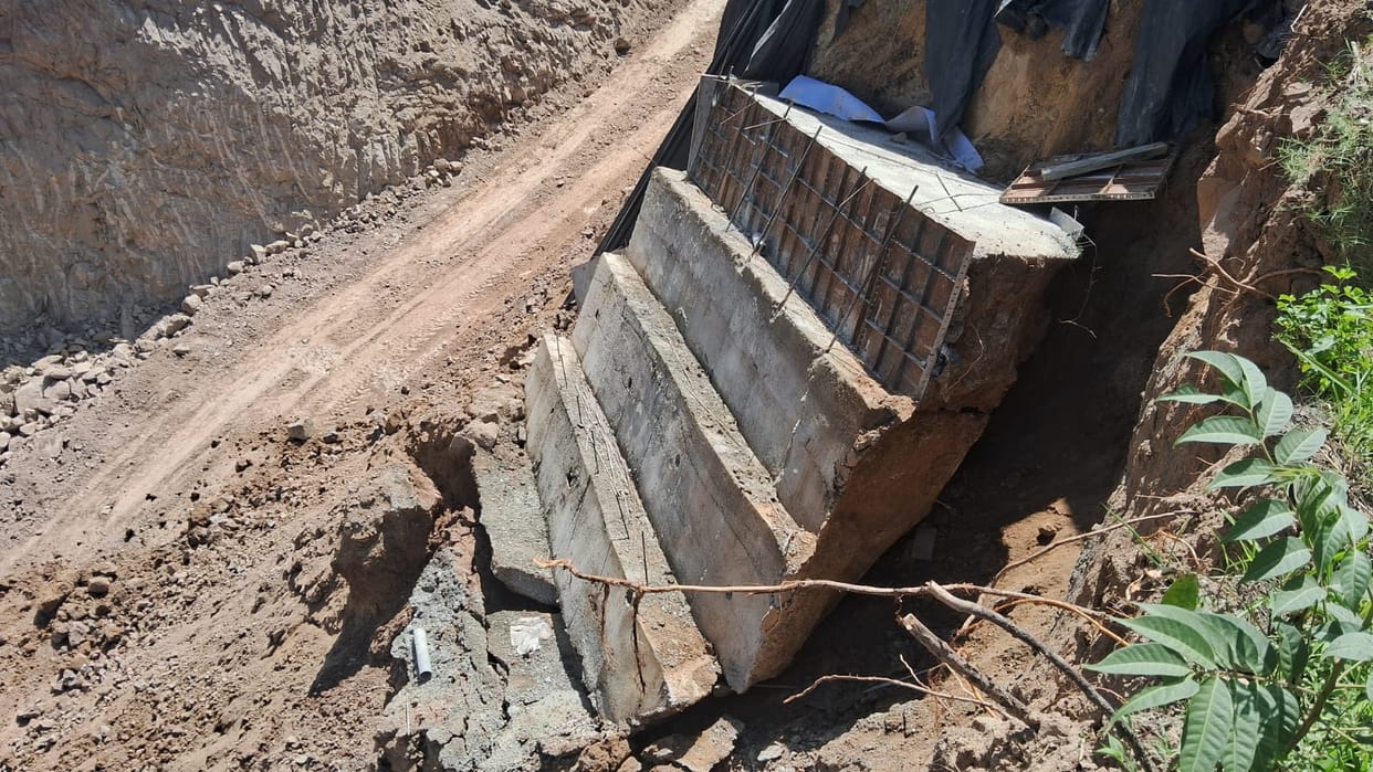 A retaining wall being constructed atop a mound of soil collapsed without any rain, shaking even the foundation of the nearby house.