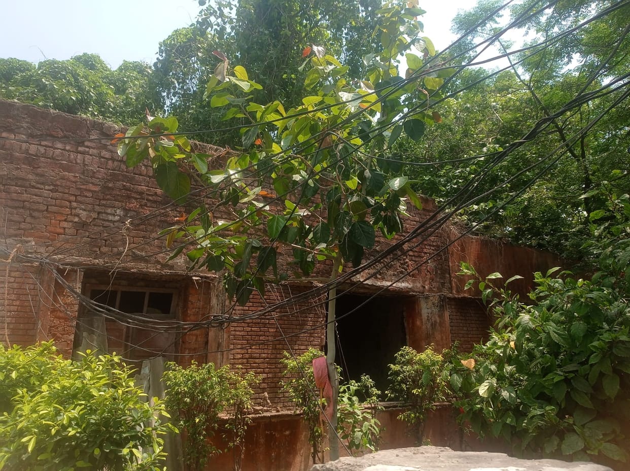 Children studying in dilapidated community buildings with crumbling roofs and walls.