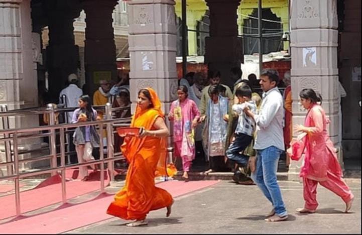The pink stones, heated by the scorching sun, are turning red; at the Mother Goddess's shrine, the feet of devotees are burning.