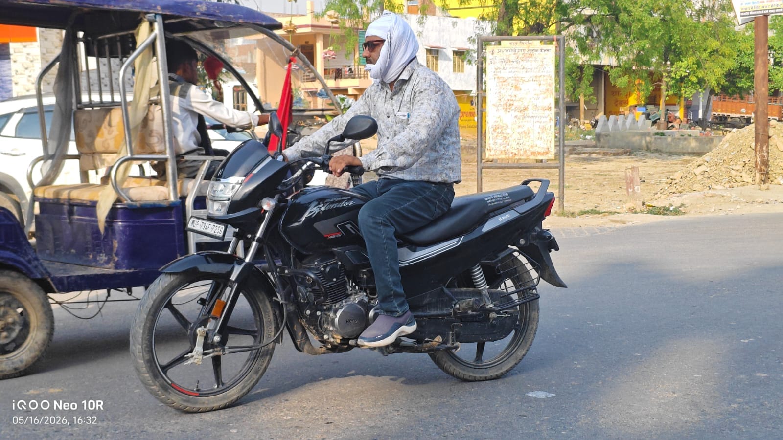 मंझनपुर चौराहे से सिराथू की ओर धूप से बचने के लिए रूमाल बांधकर जाता बाइक सवार। संवाद