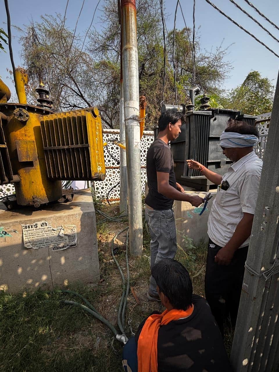 डीएम कालोनी में ट्रांसफार्मर में लोड बढ़ाते बिजली कर्मी। संवाद