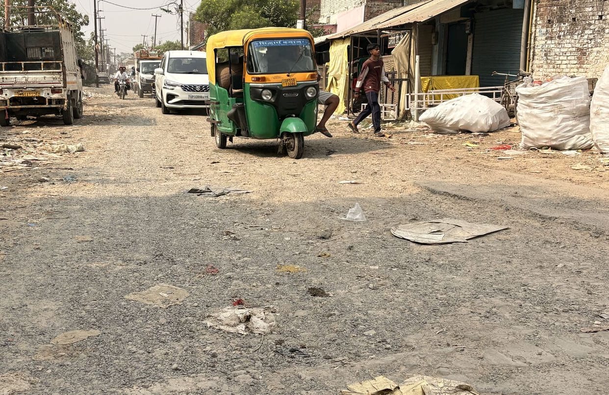 The Naveen Mandi road is full of potholes, and people jolt along it.