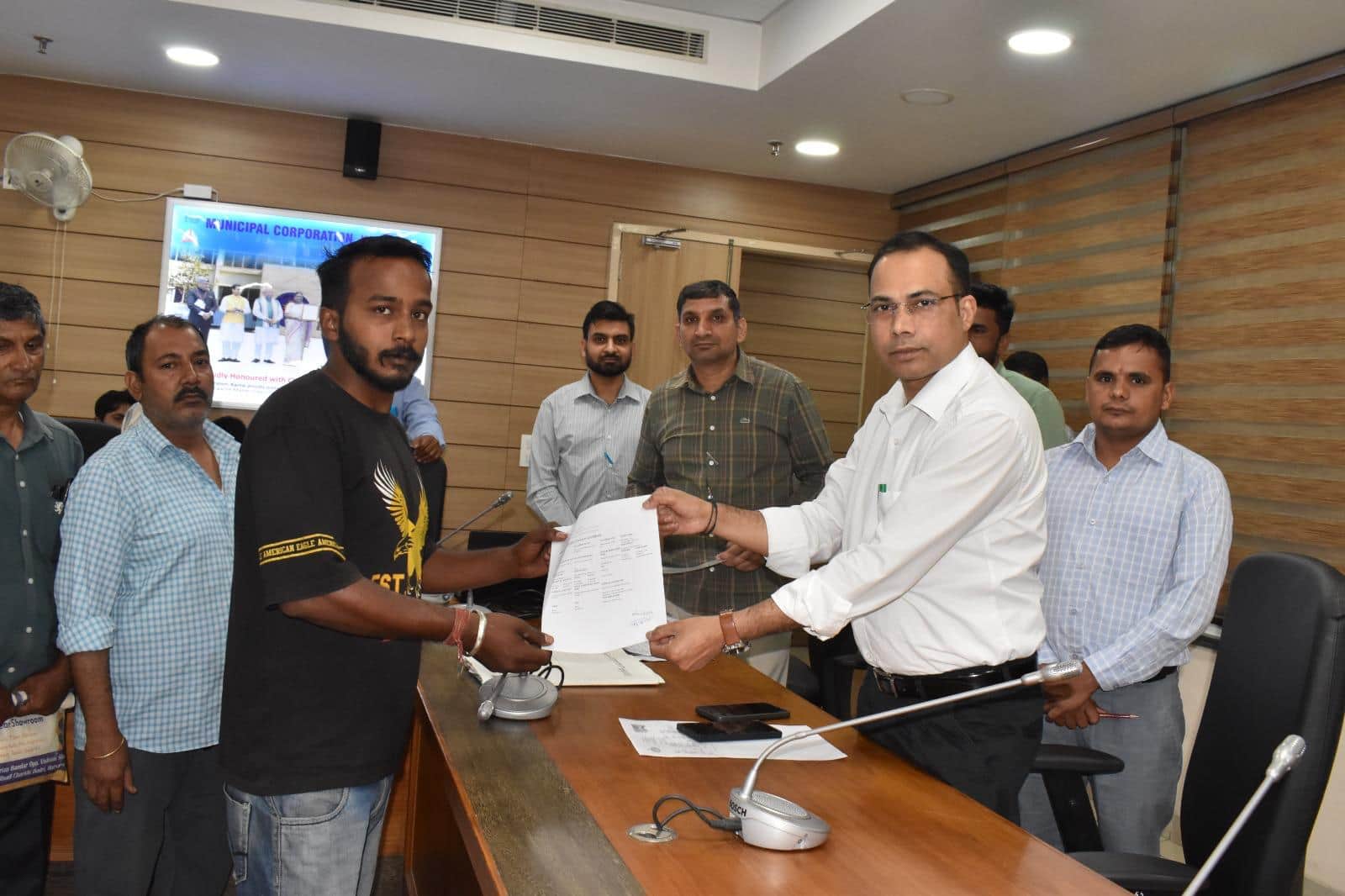 लाभार्थी को लाल डोरा संपत्ति प्रमाण पत्र देते  नगर निगम के संयुक्त आयुक्त दलजीत सिंह। संवाद