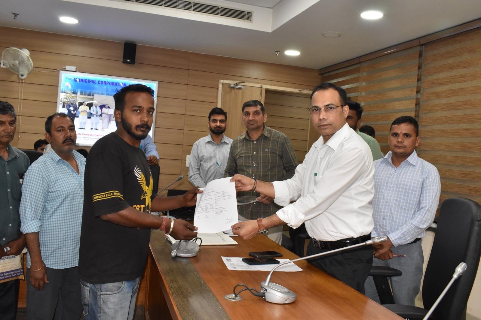 लाभार्थी को लाल डोरा संपत्ति प्रमाण पत्र देते  नगर निगम के संयुक्त आयुक्त दलजीत सिंह। संवाद