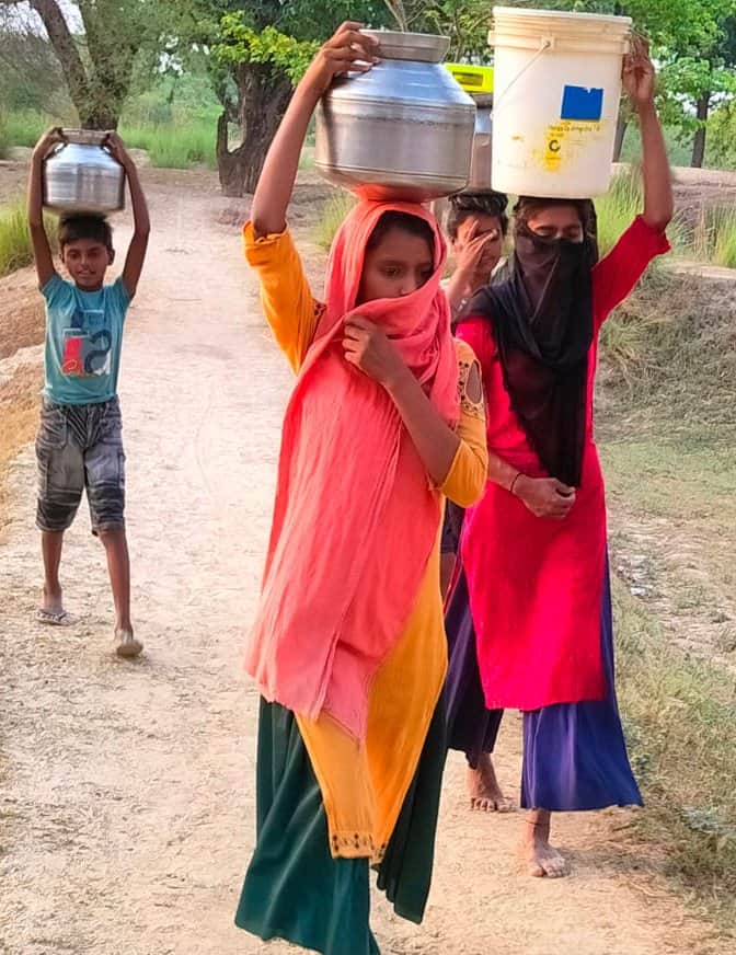 शिवगढ़ के कमलेश्वरनाथ मंदिर से बसहा गांव एक किमी दूर पानी ले जाती महिलाएं। संवाद