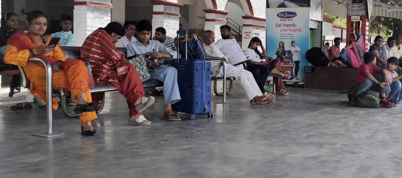 रेलवे स्टेशन पर ट्रेन के इंतजार में गर्मी में बैठे यात्री। अमर उजाला