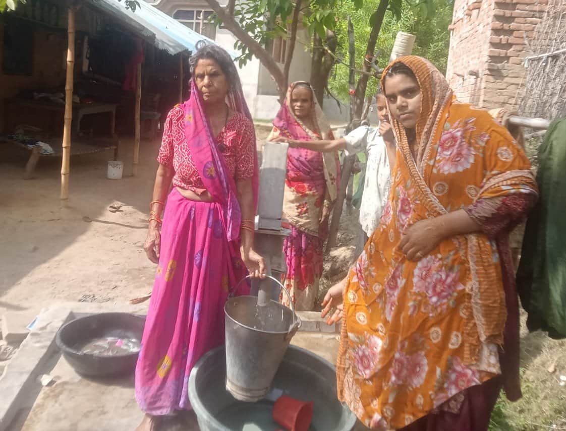 मानधाता के मदईपुर में हैंडपंप से पानी लेतीं महिलाएं। संवाद