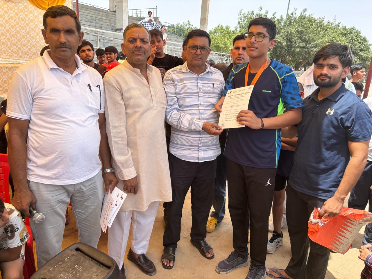 फ़ोटो-90: विजेता खिलाड़ी को पुरस्कार देकर सम्मानित करते आयोजक। स्रोत संघ