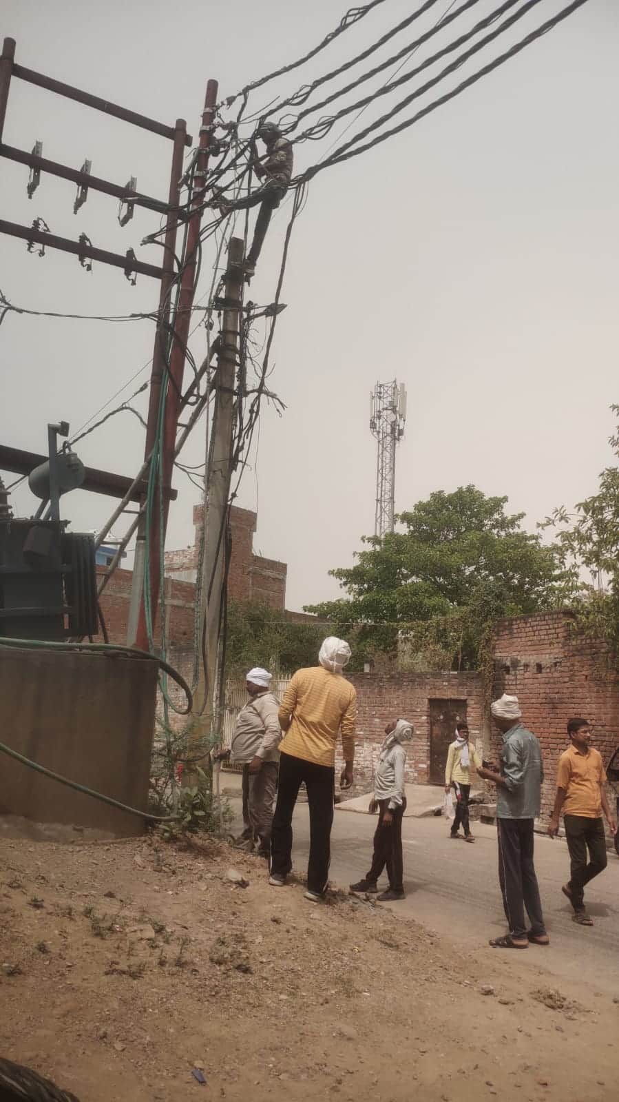 फोटो - 20 फूटा कुआं मोहल्ले में खराब ट्रांसफार्मर को ठीक करते बिजली कर्मी। संवाद