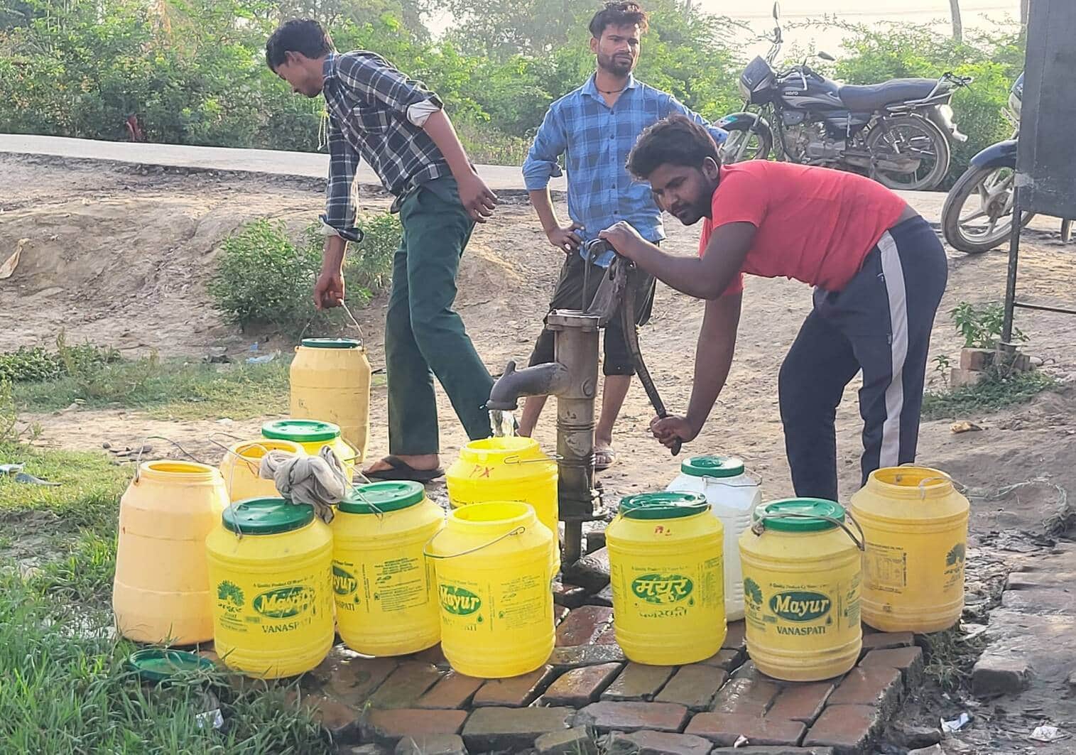 फोटो-17-परियर गांव के बाहर लगे हैंडपंप से पानी भरते लोग व रखे डिब्बे। संवाद
