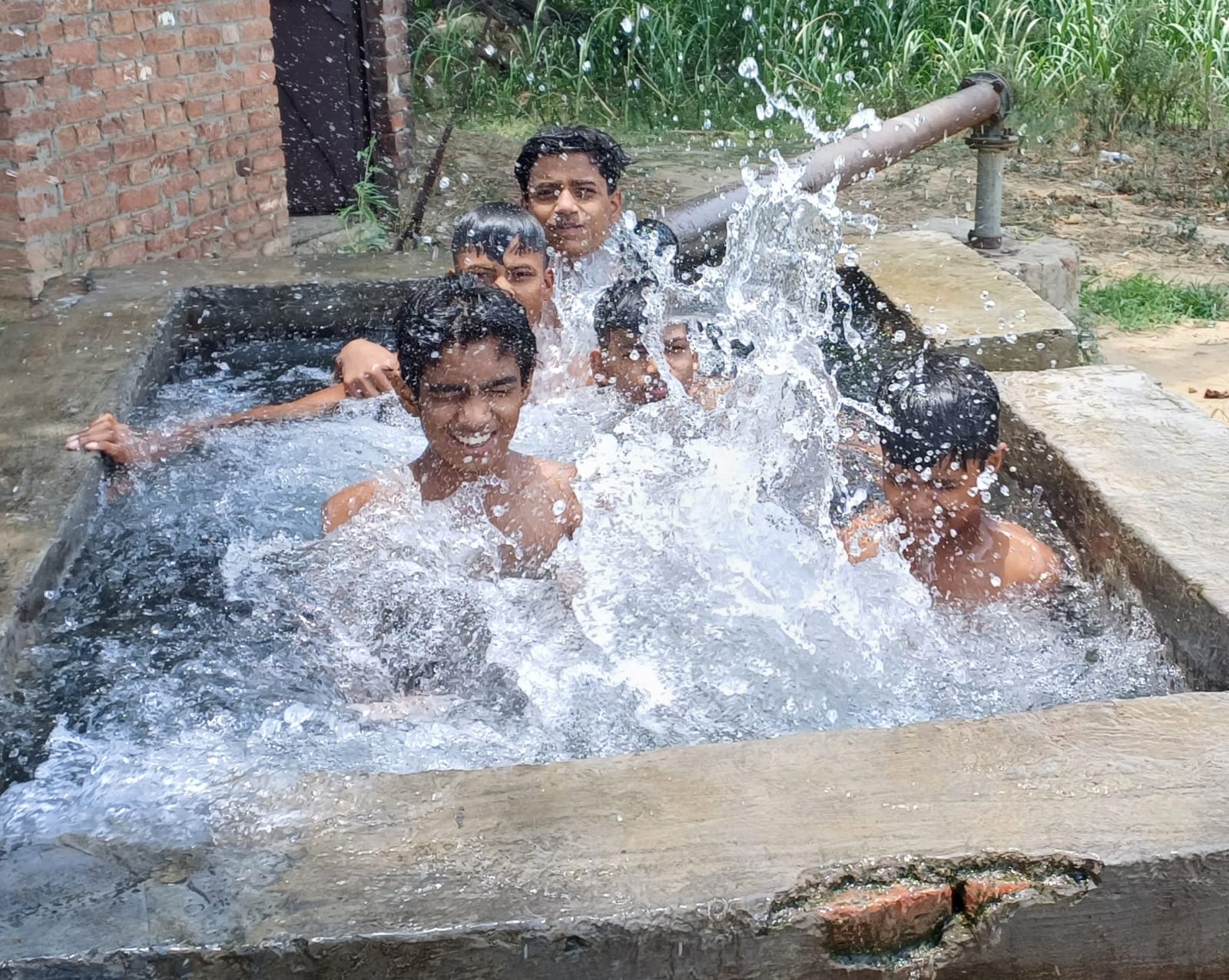 गर्मी में ट्यूबवेल पर नहाते बच्चे। संवाद