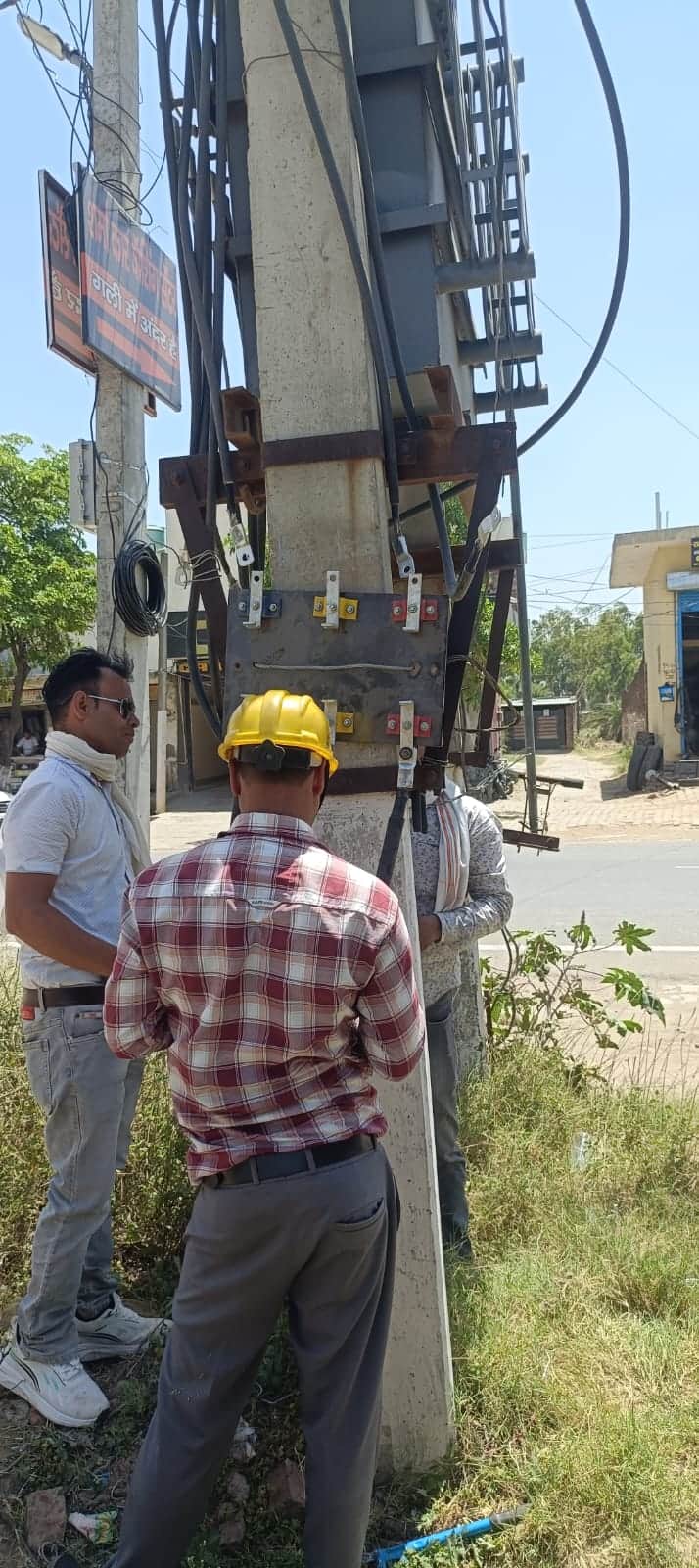 ट्रांसफार्मर के टूटे फ्यूज को लगाते कर्मचारी। संवाद