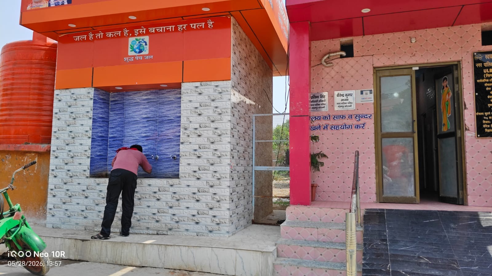 मंझनपुर चौराहे पर लगे वॉटर कूलर से राहगीर ठंडा पेयजल पी हुए। संवाद