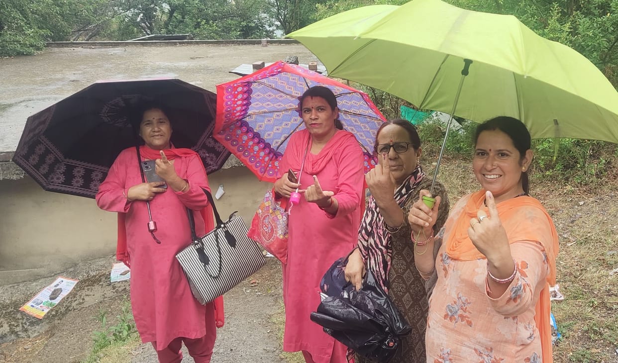 Even the rain could not dampen the enthusiasm of voters, who arrived carrying umbrellas.