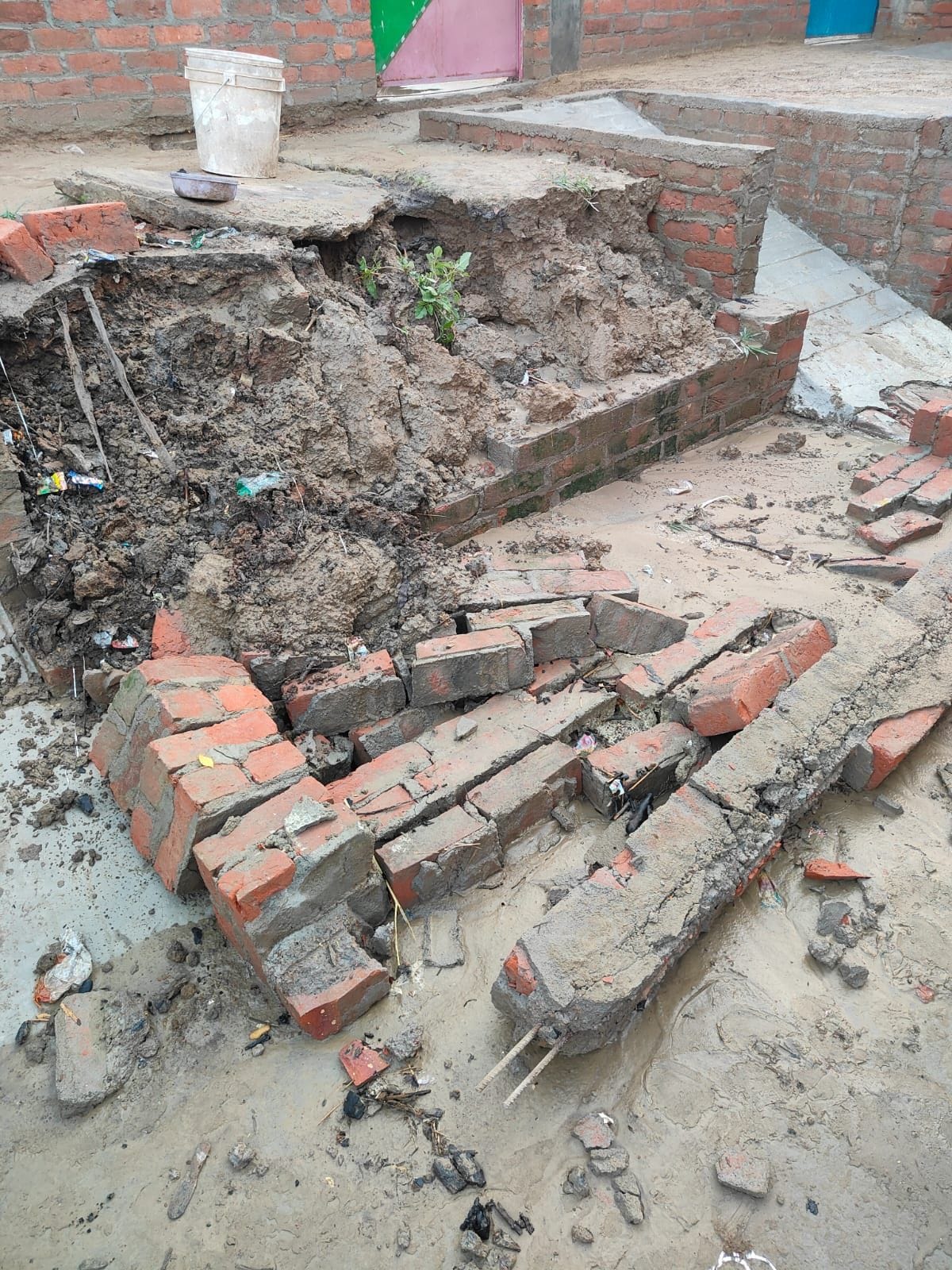 A child died after being crushed under a platform wall that collapsed during the rain
