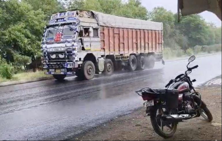 नेशनल हाईवे पर जलालपुर के पास हल्की बारिश के बीच गुजरता ट्रक। - संवाद 