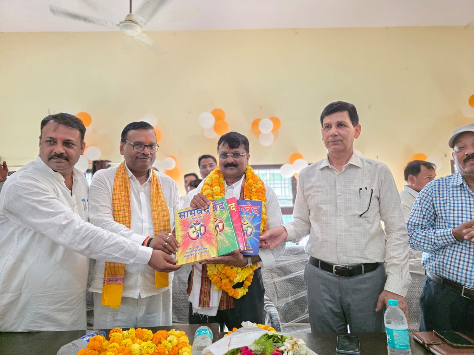 बीडीओ नेवादा के सेवानिवृत्त होने पर उन्हें चारों वेद की पुस्तकें और उपहार देकर सम्मानित करते भा