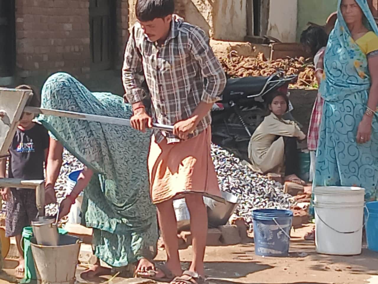 फोटो - 16 अमलोर गांव में हैंडपंप से पानी भरते ग्रामीण। संवाद